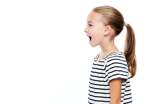 Cute little girl in stripped T-shirt talking. Speech therapy concept over white background.