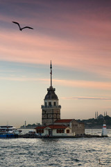 Beautiful landscape of Maiden's tower (Tower of Leandros) at sunset. View of Dramatic cloudy sky. In the distance are such landmarks as Hagia Sophia, Blue Mosque and Topkapi Palace. Istanbul. Turkey.