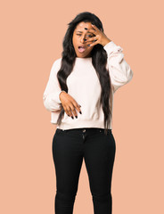 Young afro american woman with surprise and shocked facial expression on isolated brown background