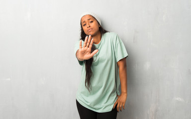 Young afro american woman on textured background making stop gesture denying a situation that...
