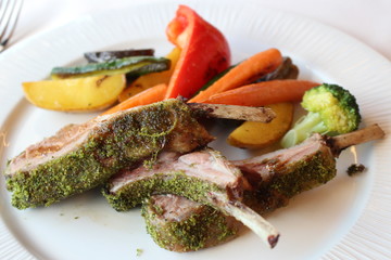 Grilled lamb chops with vegetables on a white plate