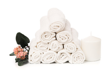 set of white roll towels with flowers and candles isolated on white.