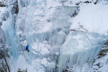 Ice climbing the North Greece, man climbing frozen waterfall.