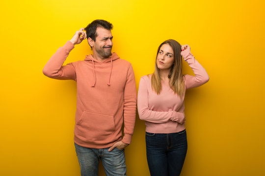 Group Of Two People On Yellow Background Having Doubts While Scratching Head