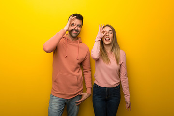 Group of two people on yellow background makes funny and crazy face emotion