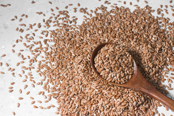 Scattered flax seeds on a grey table. Organic food