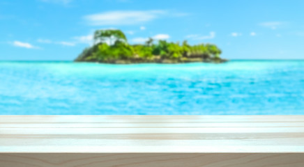 Empty table top for product display montage. Tropical holiday concept. Paradise island and ocean blurred in the background.