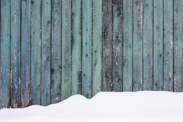 Minimalist shot of huge snowdrift under the wooden rustic fence.