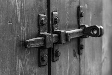 Padlock on the garage door. Gate locked on the castle. Vintage, old.Door hinges. closed.