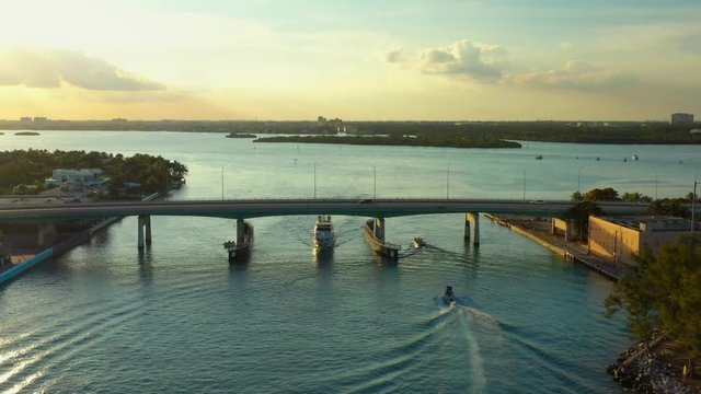 Aerial footage boat passing under bridge Miami