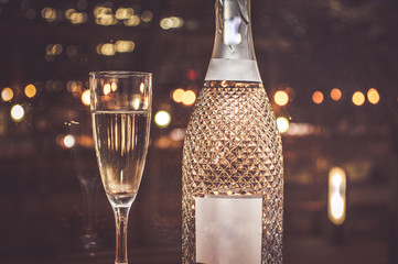 Champagne glass with fine champagne in front of the lights of a big city