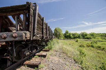 Abandoned Mine Carts. Weathered abandoned wooden mine cars on rusty railroad tracks in an empty barren landscape. 