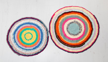 Colorful crochet rug from repurposed T-shirts at home floor. Flat lay view.