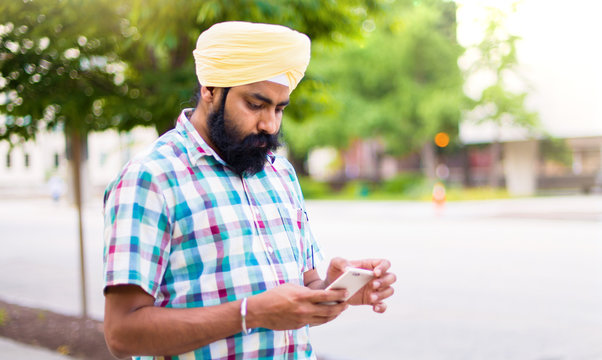 Indian With Turban Using Mobile Phone In Outdoors