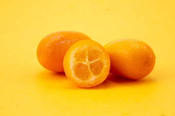Ripe kumquats on yellow background

