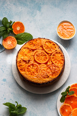 Upside down tangerine cake on a sky blue stone or concrete background.