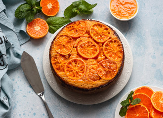 Upside down tangerine cake on a sky blue stone or concrete background.