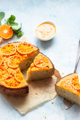 Upside down tangerine cake on a sky blue stone or concrete background.