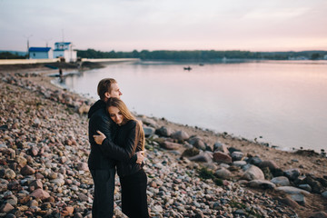 Fototapeta premium Love is in the air. Beautiful young couple embracing and smiling outdoors