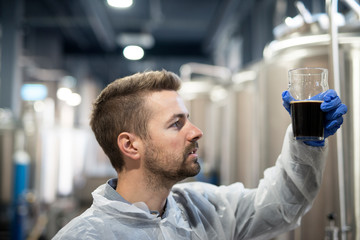 Technologist in brewery checking beer quality.