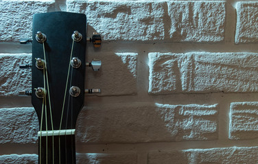 black guitar and white brick wall