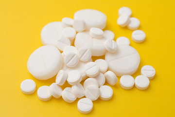 The antibiotic pills dose on a yellow background closeup