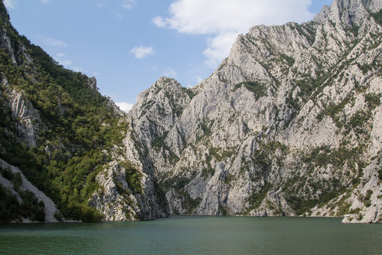 The steep cliffs from the ferry on the beautiful and idyllic Koman lake in northern mountain ridge in Albania