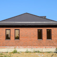 The house with plastic windows and a roof of corrugated sheet. B