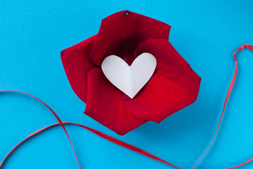 background for Valentine's day and eighth of March, rose petals and heart in box on blue background.the view from the top