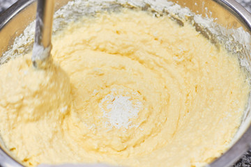 Mixing dough swirl, close up. Close up yellow dough in a bowl that is mixing.