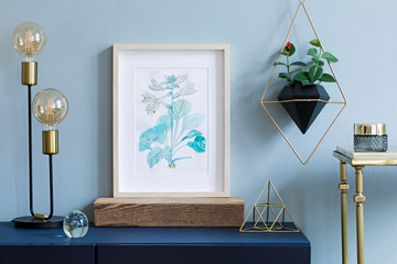 Still life with lamp, poster in wooden frame and potted plant