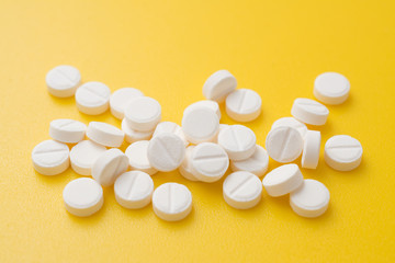 aspirin pills on yellow background close up photo