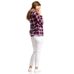 Woman in white jeans and shirt talking smartphone on white background isolation, back view