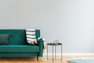 Minimalistic and luxury grey home interior with green velvet design sofa ,coffee table, elegant...