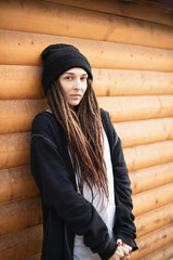 portrait of a young girl with dreadlocks in a black hat and a black hoodie