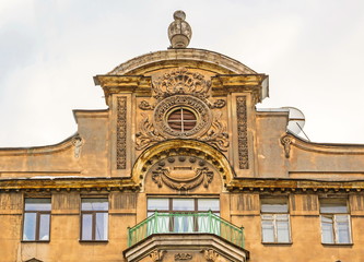 Fototapeta premium Fragment of the facade of an old house with a tower, stucco and a balcony