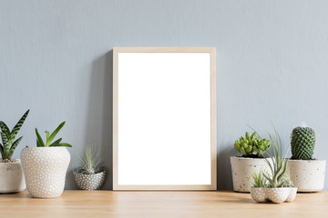 Minimalistic room interior with mock up photo frame on the brown wooden table with beautiful cacti...