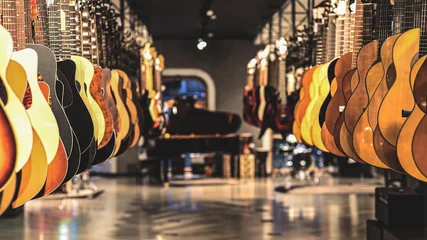 Tuinposter Muziekwinkel gitaren, vitrine met gitaren die op een rij hangen