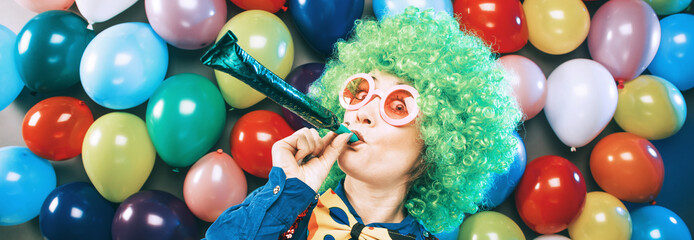 Frau in Karnevalstimmung auf einem bunten Hintergrund aus Luftballons 