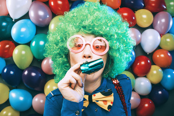 Frau in Karnevalstimmung auf einem bunten Hintergrund aus Luftballons 