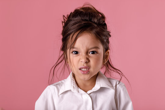 angry little child girl in white shirt with hairstyle