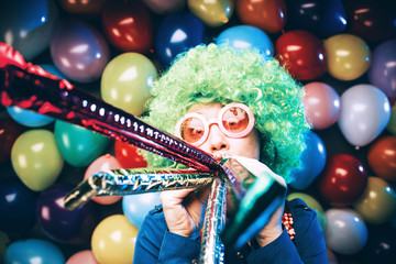 Frau in Karnevalstimmung auf einem bunten Hintergrund aus Luftballons 