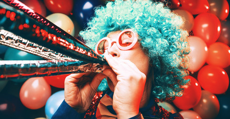 Frau in Karnevalstimmung auf einem bunten Hintergrund aus Luftballons 