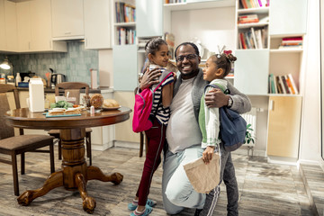 Father feeling happy after family breakfast together with daughters