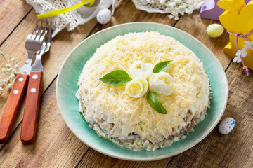Festive snack on Easter table. Salad with eggs, chicken, mushrooms and cheese.
