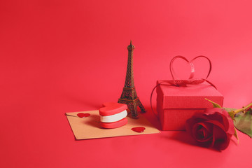 Empty Valentine's card with hearts and souvenir eiffel tower on a red table. The concept of a romantic trip to Paris for two