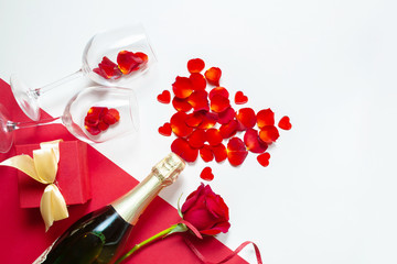 Two glasses with rose petals and a bottle of wine for Valentine's Day