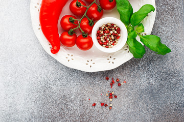 Ingredients for cooking. Cherry tomatoes, paprika, basil, pink pepper, sea salt, pasta on a light background. Top view. Copy space