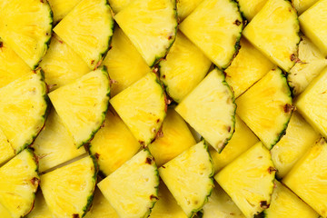 Pineapple juicy yellow slices background. Top view.