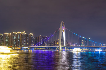 Fototapeta na wymiar Guangzhou cityscape skyline over the Pearl River with Liede Bridge illuminated in the evening. Guangzhou, China